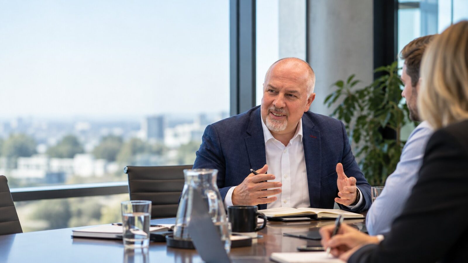 Martyn Pointer in discussion with a leadership team around a boardroom table